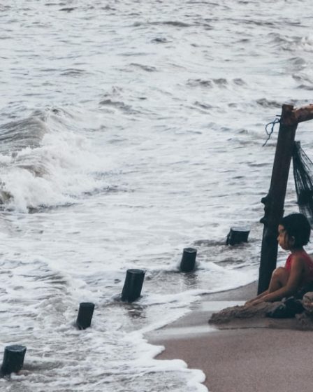 A father and son look at the stormy ocean.