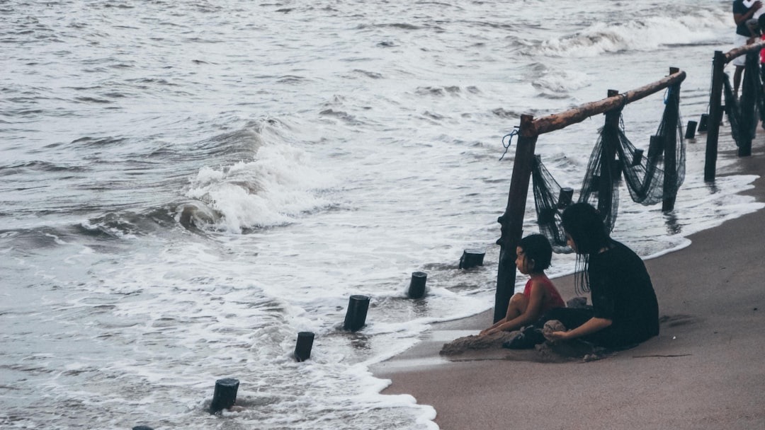 A father and son look at the stormy ocean.
