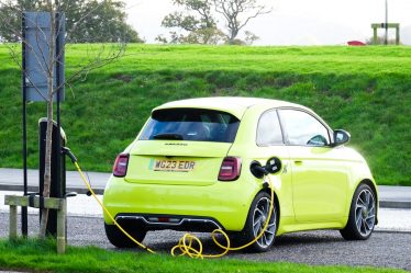 a yellow car is plugged into a charging station