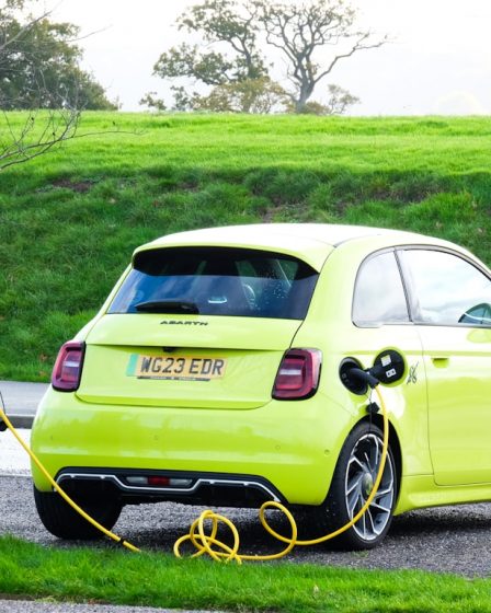 a yellow car is plugged into a charging station