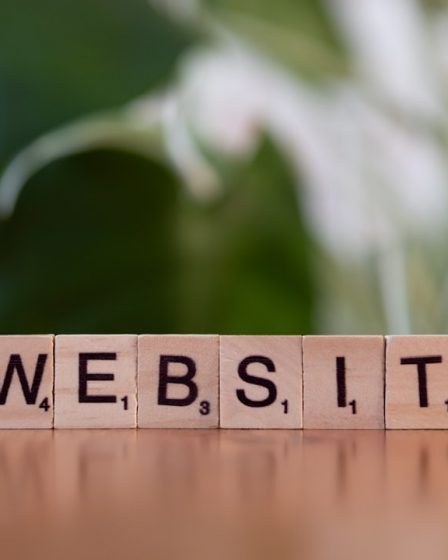 A wooden block spelling the word website on a table