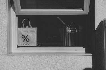 A black and white photo of a shopping bag in a window