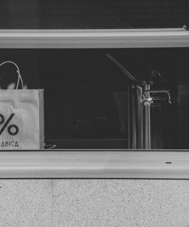 A black and white photo of a shopping bag in a window