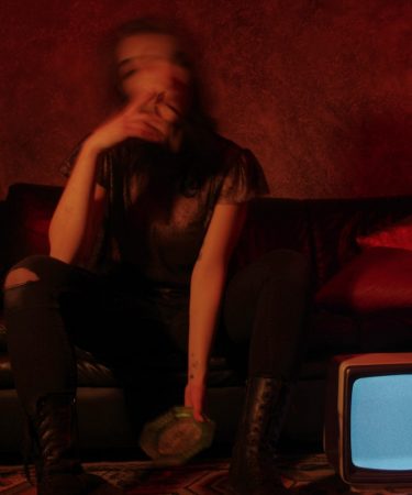 a woman sitting on a couch in front of a tv