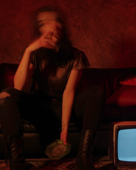 a woman sitting on a couch in front of a tv