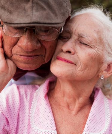 An older couple is embracing each other
