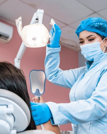 a woman getting her teeth checked by a dentist
