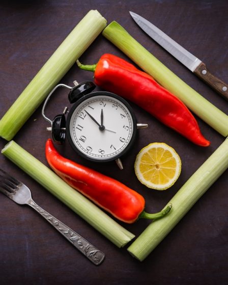 a clock surrounded by vegetables and a knife