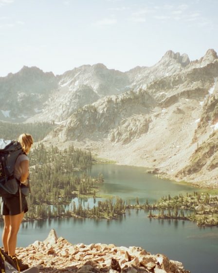 a person with a backpack standing on top of a mountain