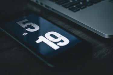 black smartphone beside laptop