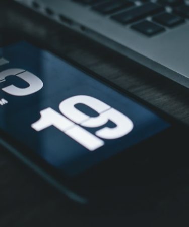 black smartphone beside laptop