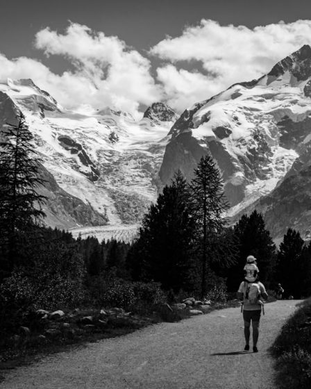 a black and white photo of a person walking down a road