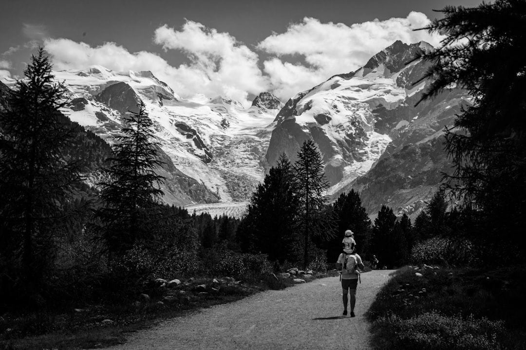 a black and white photo of a person walking down a road