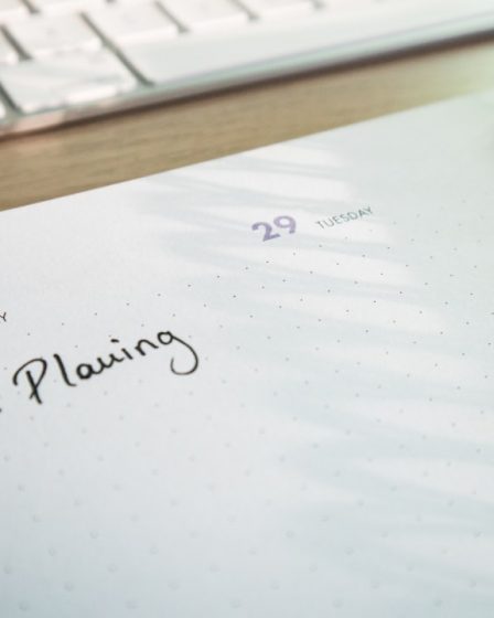 a notepad with a planner and a keyboard in the background