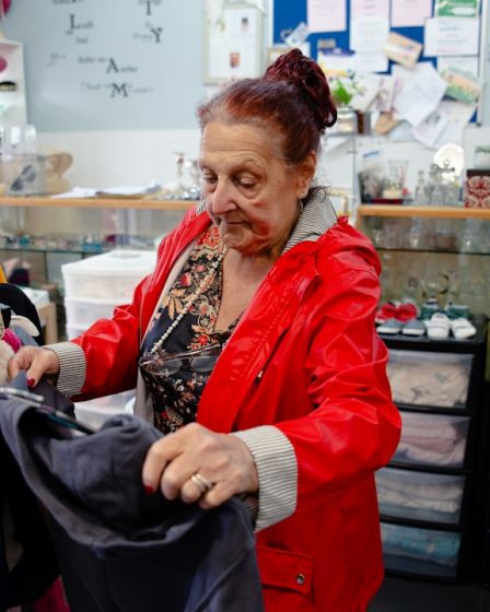 Elderly woman sorting clothes in a store